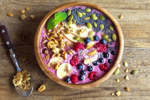 Smoothie bowl with fresh berries, nuts, seeds and homemade granola for healthy vegan vegetarian diet breakfast